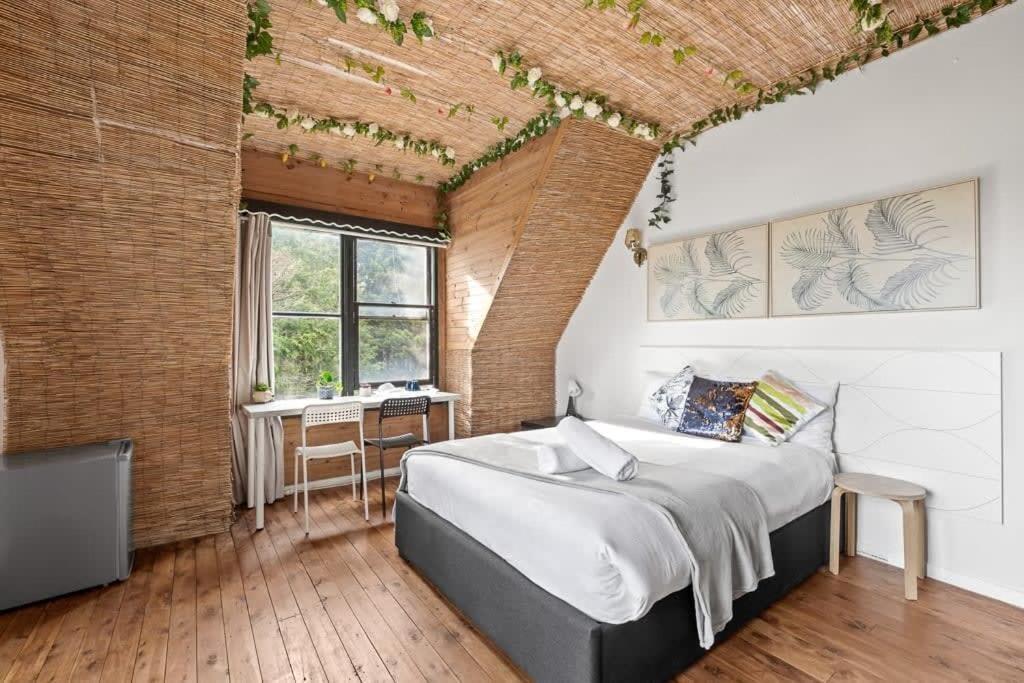 Private Room in Sans Souci Guesthouse في سيدني: غرفة نوم بسرير كبير وجدار من الطوب