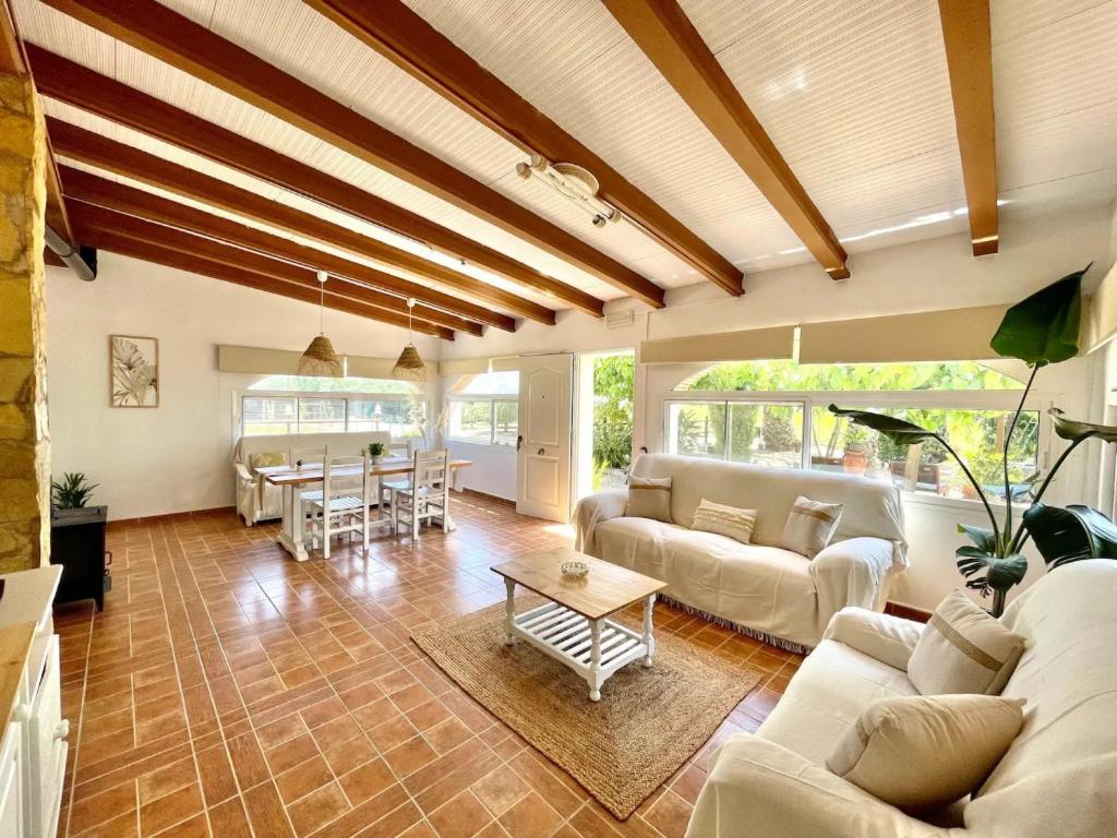 uma sala de estar com sofás brancos e uma mesa em Villa Delta em L'Eucaliptus