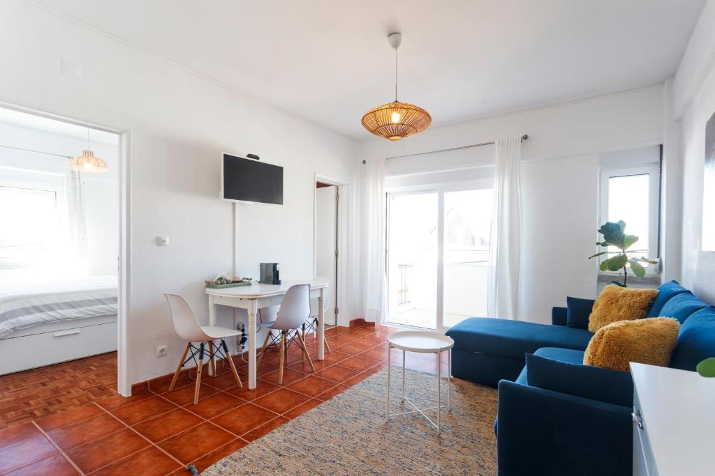 a living room with a blue couch and a table at Beach House Cascais in Estoril