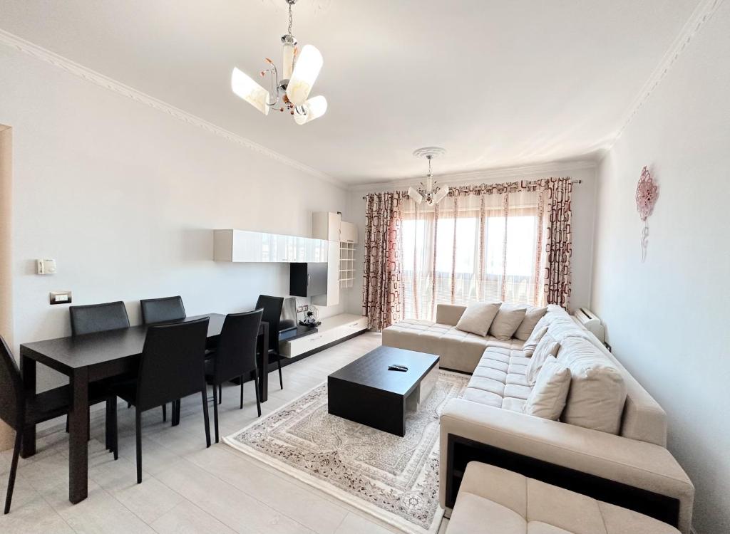 un salon avec un canapé et une salle à manger dans l'établissement Tirana Family Suite, à Kashari