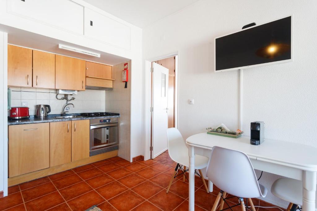 a kitchen with a white table and white chairs at Beach House Cascais in Estoril