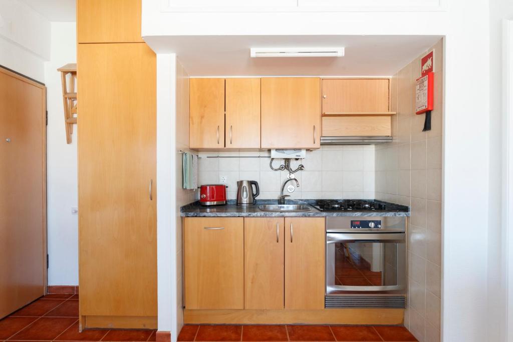 a small kitchen with wooden cabinets and a sink at Beach House Cascais in Estoril