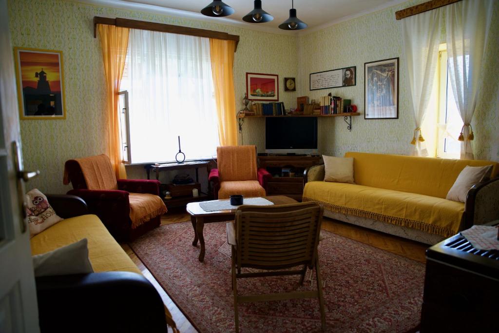 sala de estar con sofá amarillo y sillas en Kuća za odmor u Banatu 