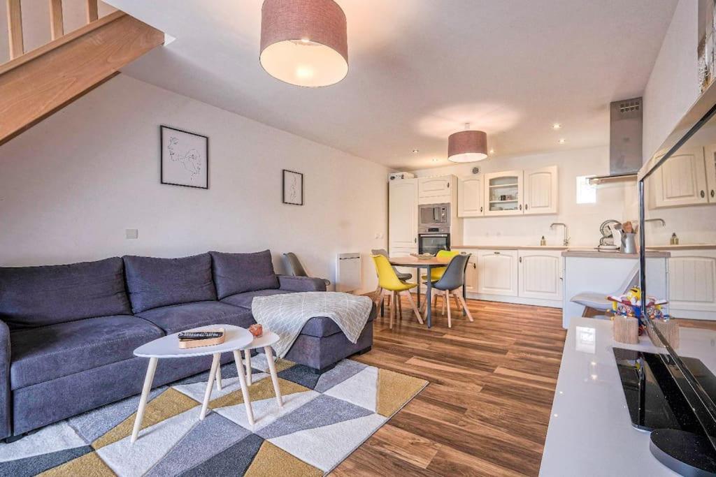 un salon avec un canapé et une table et une cuisine dans l'établissement Magnifique maison de ville - parking - proche Disney, à Fublaines