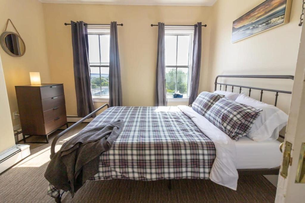 um quarto com uma cama, uma cómoda e 2 janelas em Cozy 3-Bdrm for the family, in Uptown Saint John Parking Coffee em Saint John