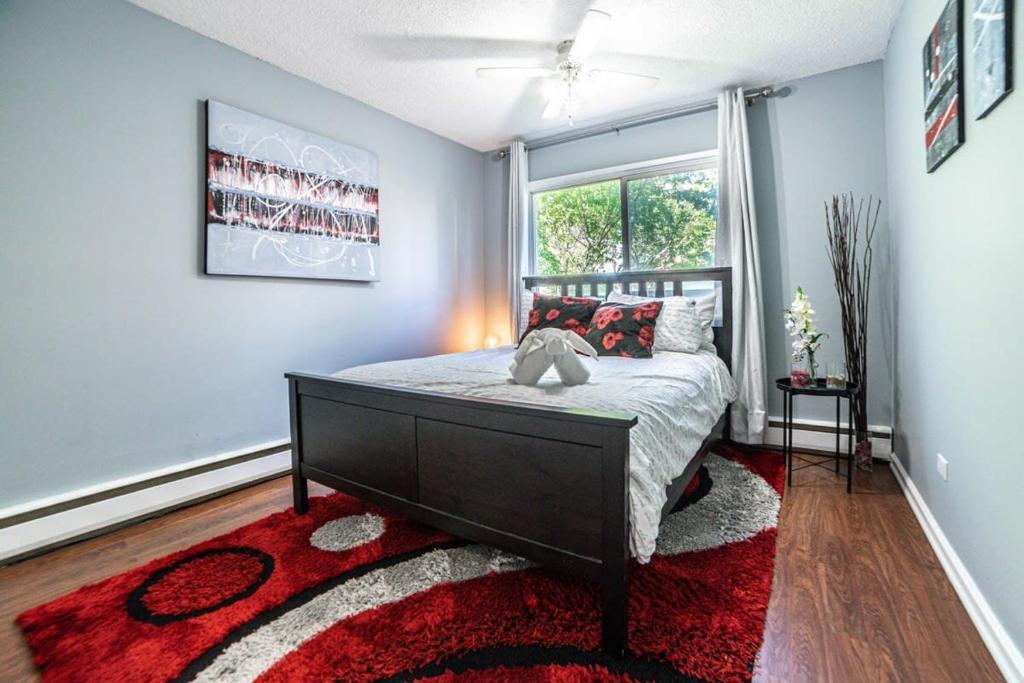 a bedroom with a bed with a red rug and a window at New Listing Outdoor Patio Beautiful 2BDR Suite Parking Coffee Wifi in Calgary