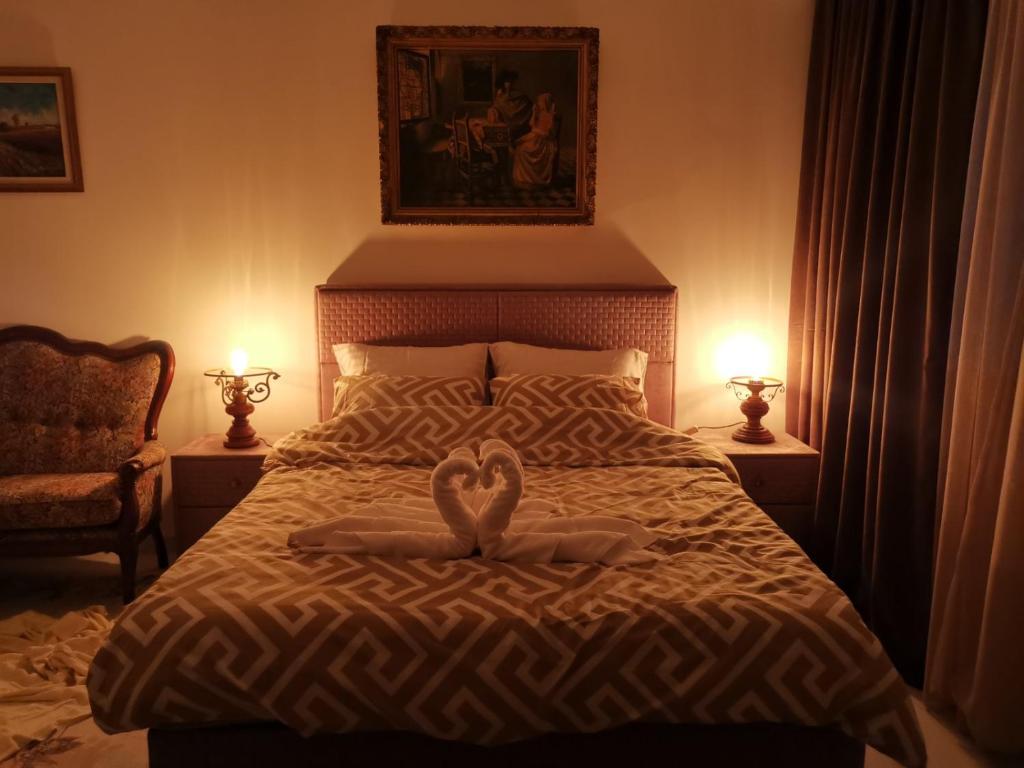 a bed with two white towels in the shape of hearts at IN Apartments AirPort in Podgorica