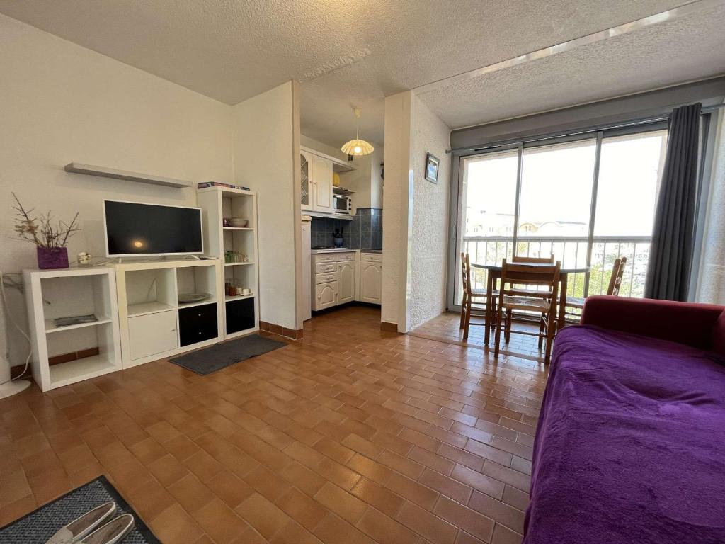 een woonkamer met een bank, een tv en een tafel bij Appartement Gruissan, 1 pièce, 3 personnes - FR-1-229-882 in Gruissan
