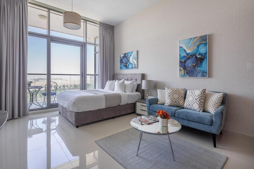 a hotel room with a bed and a couch at Frank Porter - DAMAC Hills Jasmine in Dubai