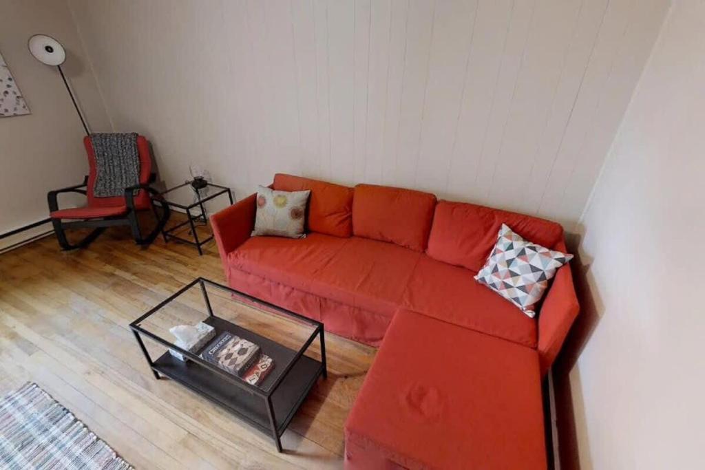 uma sala de estar com um sofá vermelho e uma mesa em Charming Home Heart Of Uptown! Location! Coffee! em Saint John