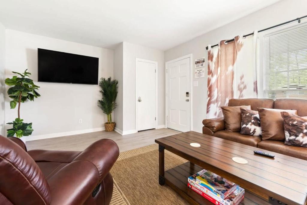 uma sala de estar com um sofá e uma mesa de centro em The Ranch 4-Bedrooms Large Yard & Patio em Mobile