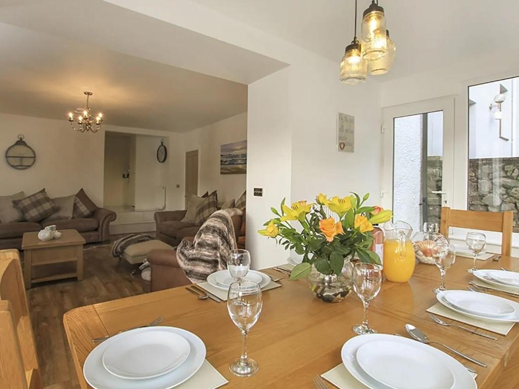 a dining room with a table and a living room at Waterside - Luxury Menai Bridge Holiday Home - 4 Bed 4 Bath in Menai Bridge