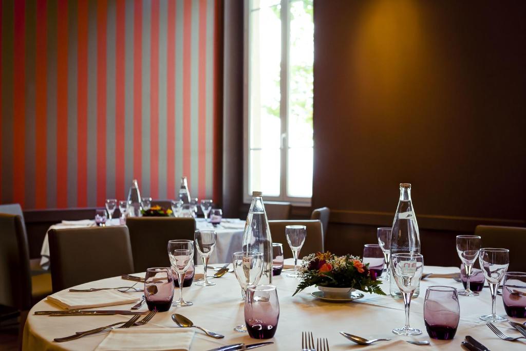 a set of tables in a restaurant with wine glasses at Domaine Lyon Saint Joseph in Sainte-Foy-lès-Lyon