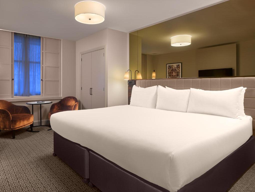 a large white bed in a hotel room at Strand Palace in London