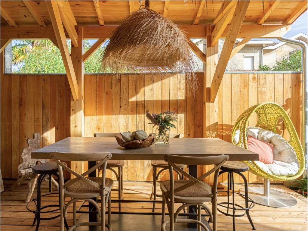 een eetkamer met een houten tafel en stoelen bij La Maison Mulatô, demeure privée d'hôtes, piscine & spa Libourne, Saint-Emilion in Libourne