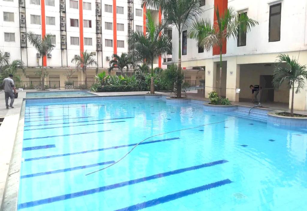 a large swimming pool in front of a building at OYO 93825 Nona Key Property in Bekasi
