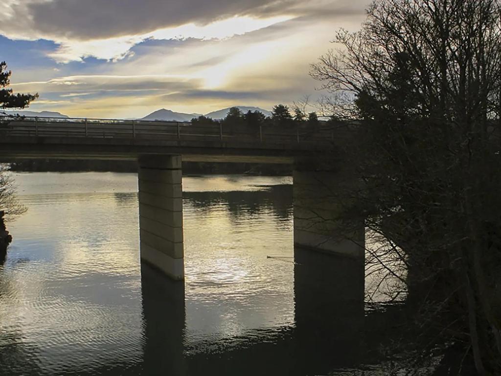 a bridge over a river with a train on it at Waterside - Luxury Menai Bridge Holiday Home - 4 Bed 4 Bath in Menai Bridge