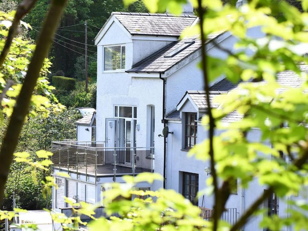 a white house with a balcony in front of it at Waterside - Luxury Menai Bridge Holiday Home - 4 Bed 4 Bath in Menai Bridge