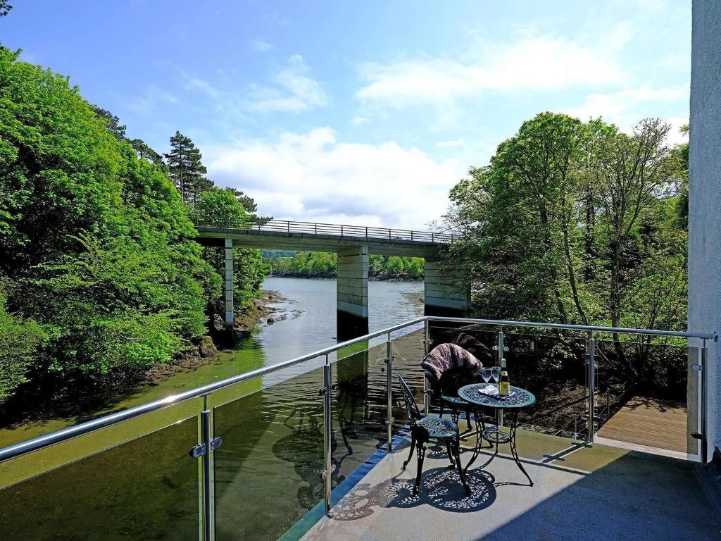 a balcony with a view of a river and a bridge at Waterside - Luxury Menai Bridge Holiday Home - 4 Bed 4 Bath in Menai Bridge