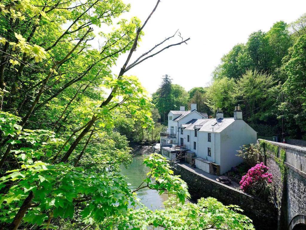 a view of a house and a river with trees at Waterside - Luxury Menai Bridge Holiday Home - 4 Bed 4 Bath in Menai Bridge