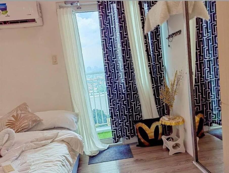 ein Schlafzimmer mit einem Bett und einem großen Fenster in der Unterkunft #68 The Grass Residence T1B-18th in Manila