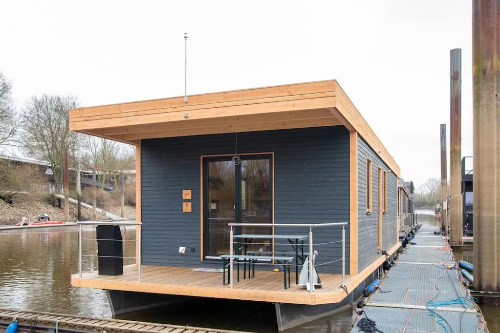 a small house on a boat in the water at Luxus-Hausboot DIVA mit Kamin in Hamburg