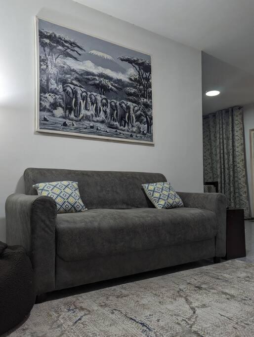 um sofá numa sala de estar com um quadro na parede em Jenty Homes em Arusha