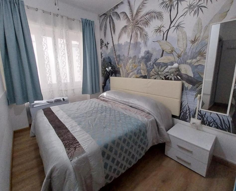 a bedroom with a bed with a tropical wallpaper at Villa La Lanterna in Pietra Ligure