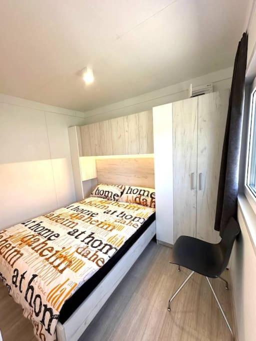 1 dormitorio con 1 cama y 1 silla en LuxCube 3, en Agarn