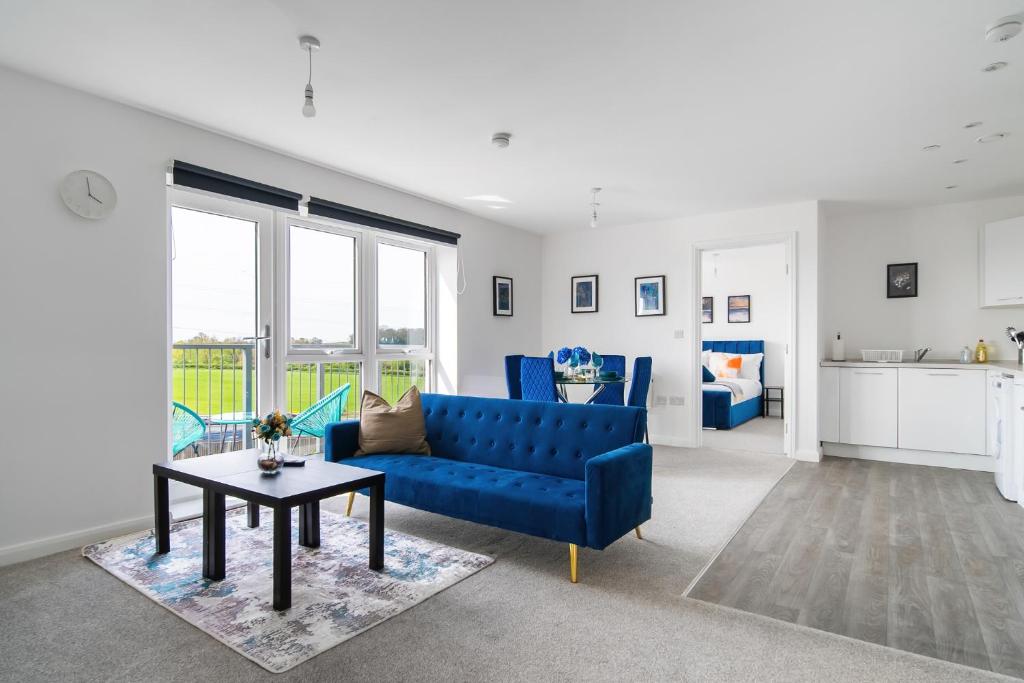 a living room with a blue couch and a table at Brand New Luton Apartments in Luton