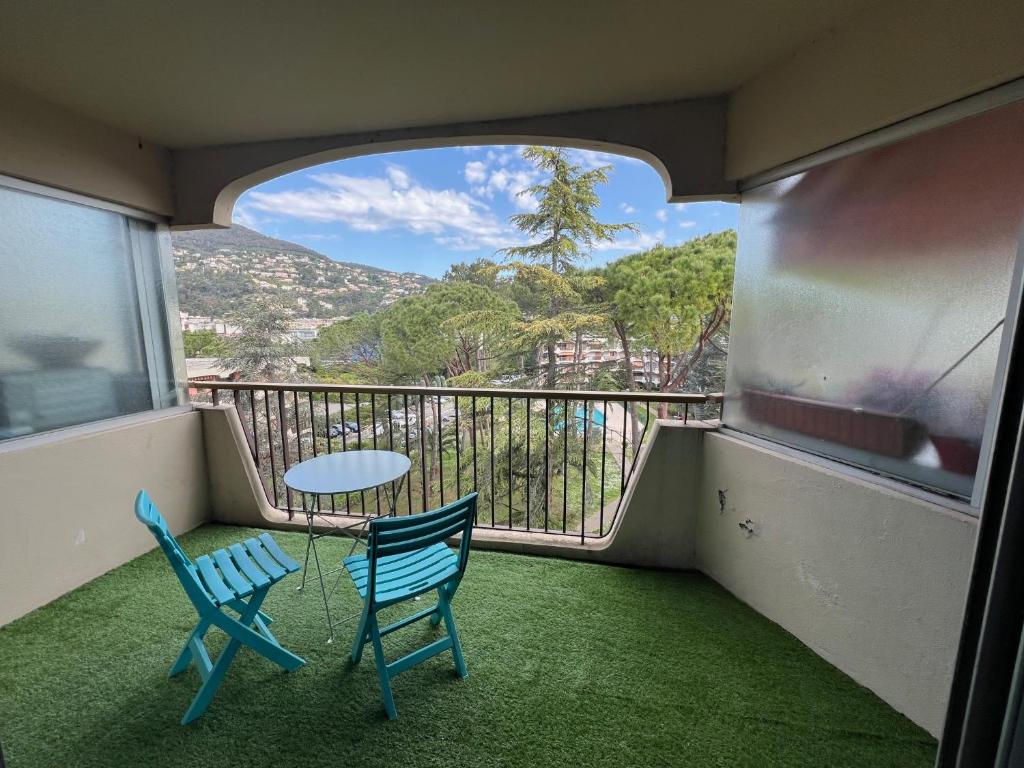 een balkon met 2 stoelen en een tafel met uitzicht bij Appartement aux 3 Rivieres a Mandelieu in Mandelieu-la-Napoule