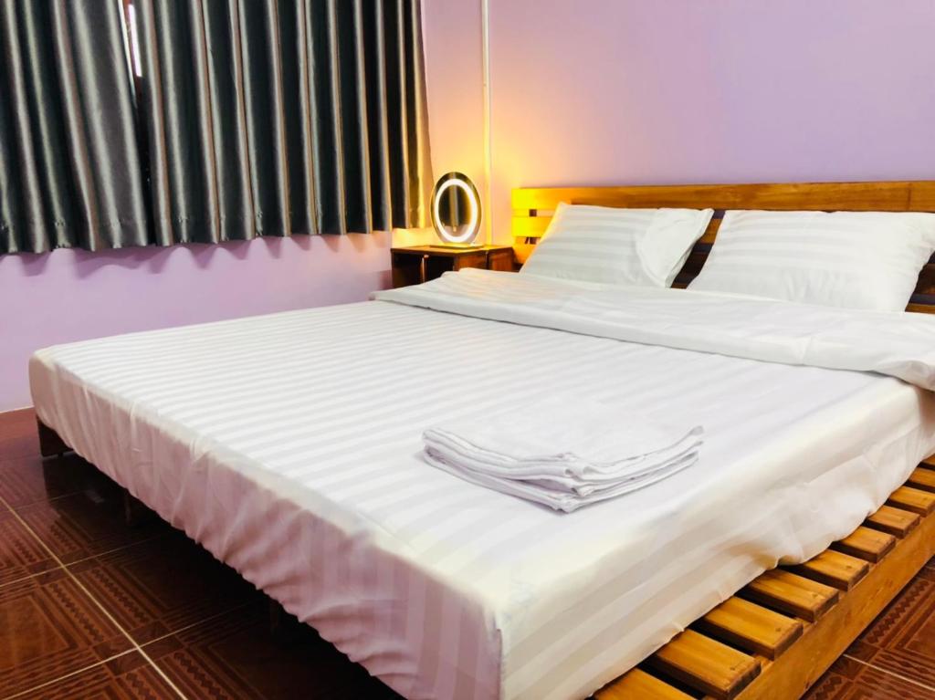 una camera con 2 letti con lenzuola bianche e tovaglioli di HOSTEL ECO TOURISM CẦN GIỜ a Cần Giờ