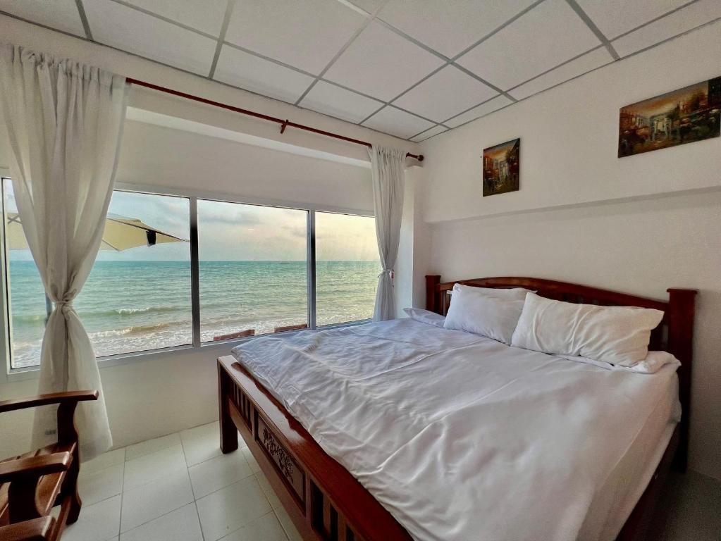 羅勇的住宿－Gao Check in Phala Beach Front，一间卧室设有一张床,享有海景