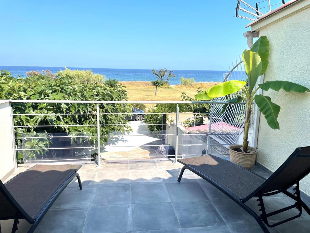 a balcony with chairs and a view of the ocean at Mini villa chaleureuse avec vue mer imprenable in San-Nicolao