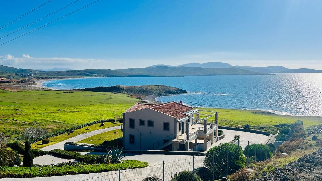 a house on a hill next to a body of water at Moutzouri Villes in Thános
