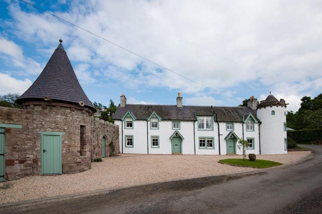 een groot wit huis met een torentje op een weg bij Dryburgh Stirling Two in Saint Boswells