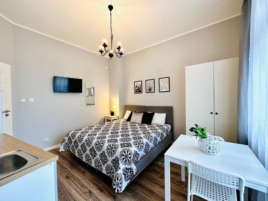 a small bedroom with a bed and a sink at Studio przy Placu Jasia Rybaka in Sopot