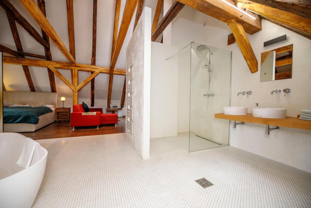 e bagno con vasca e doccia in vetro. di Hotel Svambersky dum a Cesky Krumlov