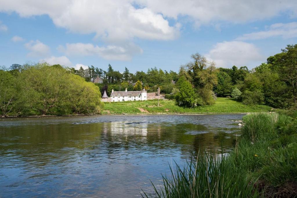 a house sitting on the side of a river at Dryburgh Stirling One in Saint Boswells