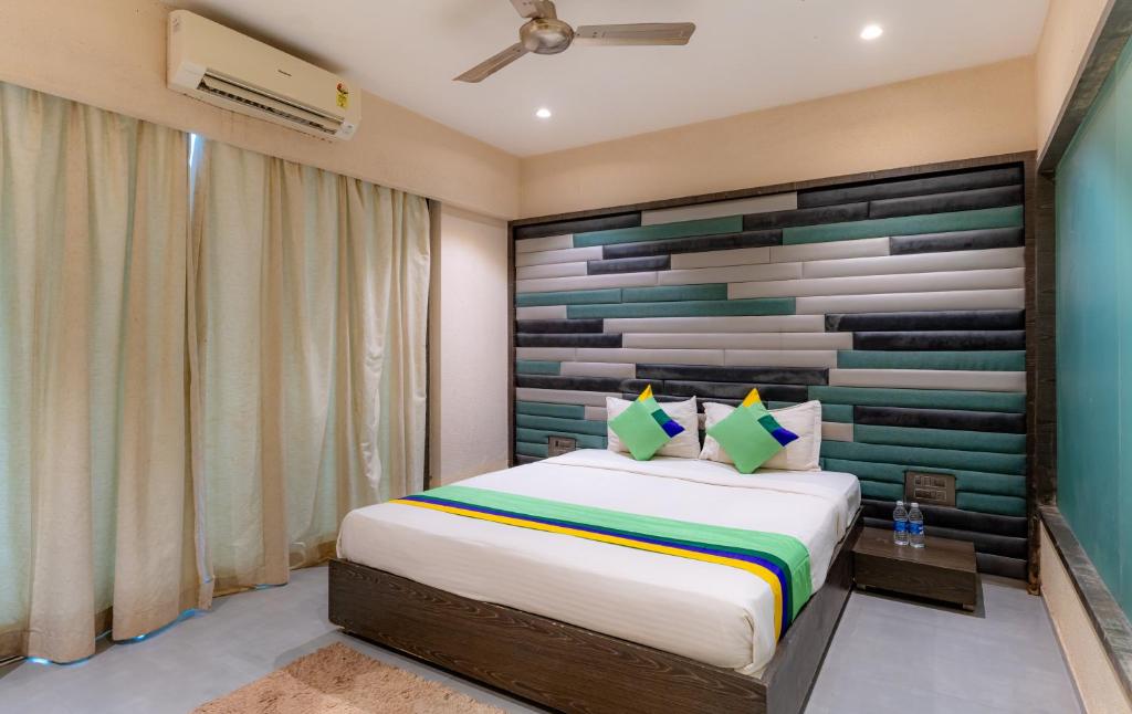 a bedroom with a large bed with a wooden headboard at Treebo Trend Supreme Grande in Calangute