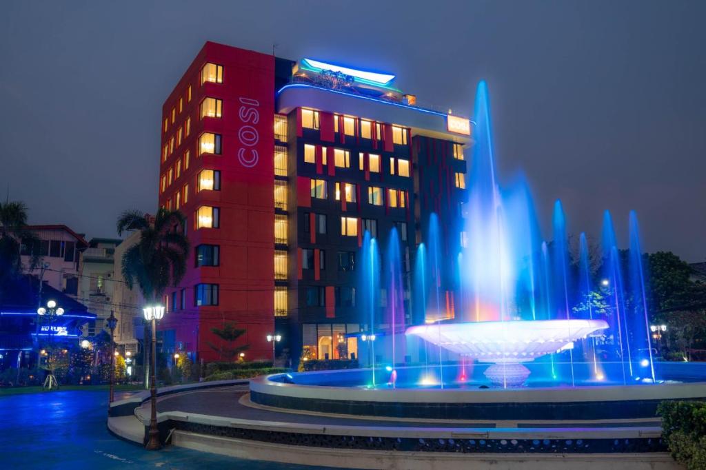 a hotel with a fountain in front of a building at COSI Vientiane Nam Phu in Vientiane