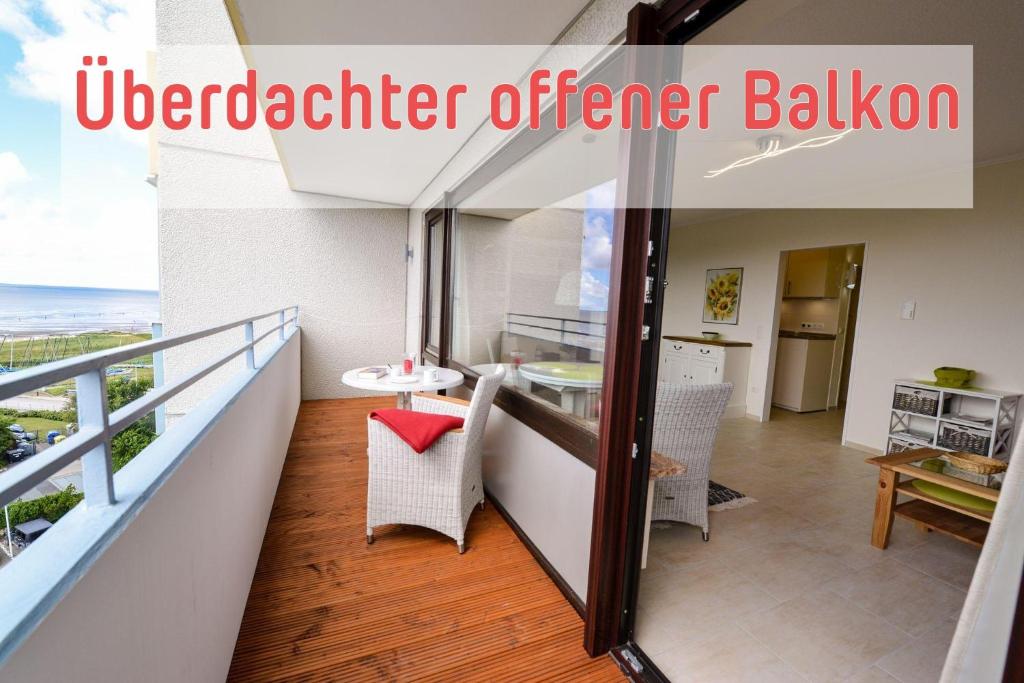 a balcony with a table and chairs and a kitchen at Strandhochhaus SD06 in Cuxhaven