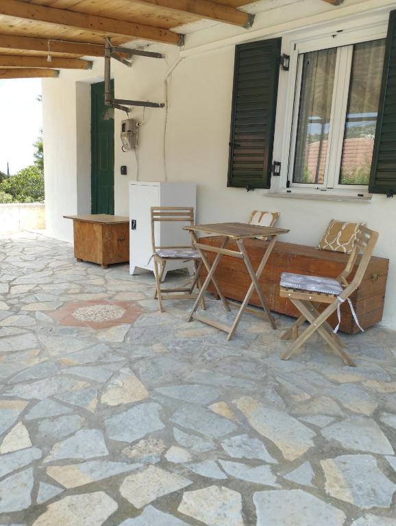 een patio met een tafel en stoelen op een stenen vloer bij Atsoupi Home in Ratzaklíon