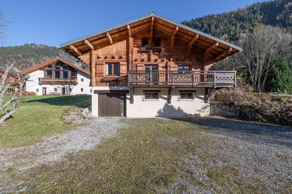 una casa de madera con un balcón en el lateral. en Chambres d'hôtes Contamines-Monjoie Tour du Mont-Blanc en Les Contamines-Montjoie
