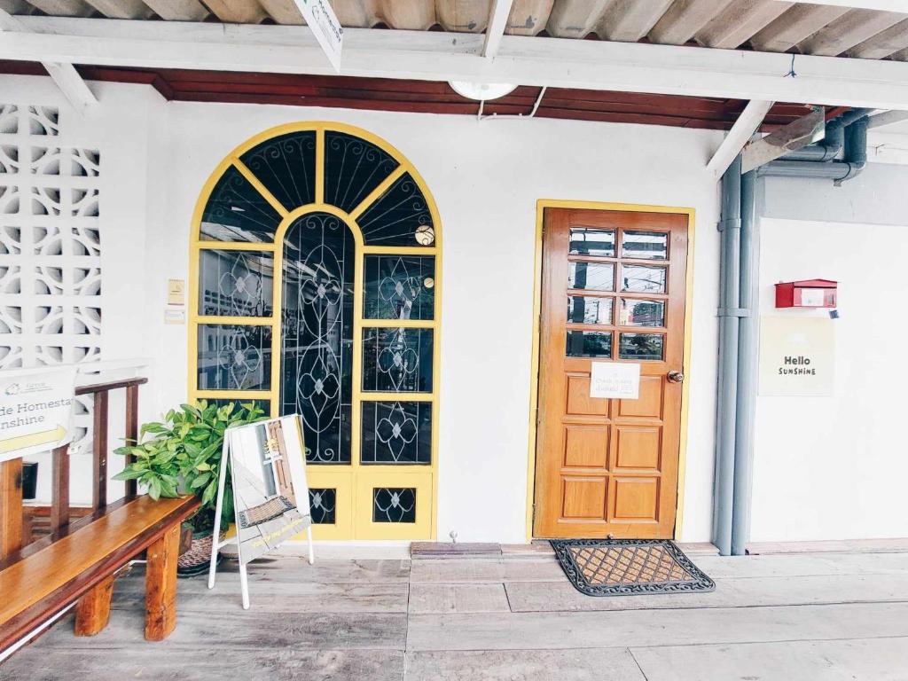 a door on a white building with a bench at Hello Sunshine in Phra Nakhon Si Ayutthaya