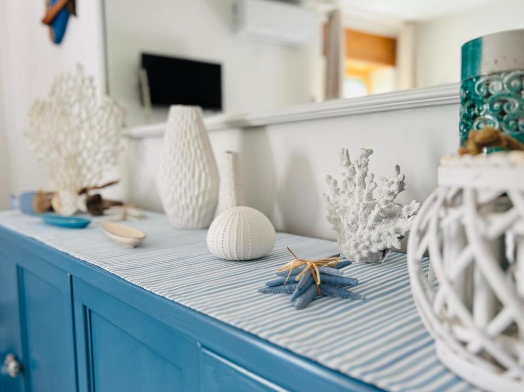 une armoire bleue avec des vases et d'autres objets dessus dans l'établissement Casa Beluga, à Pisciotta