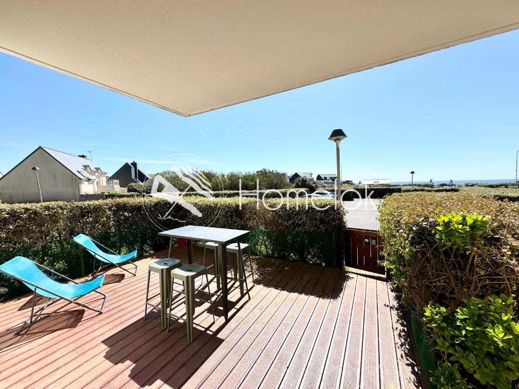 eine Terrasse mit einem Tisch und Stühlen auf einer Terrasse in der Unterkunft Joli appartement cosy – Terrasse face à la mer in Ploemeur
