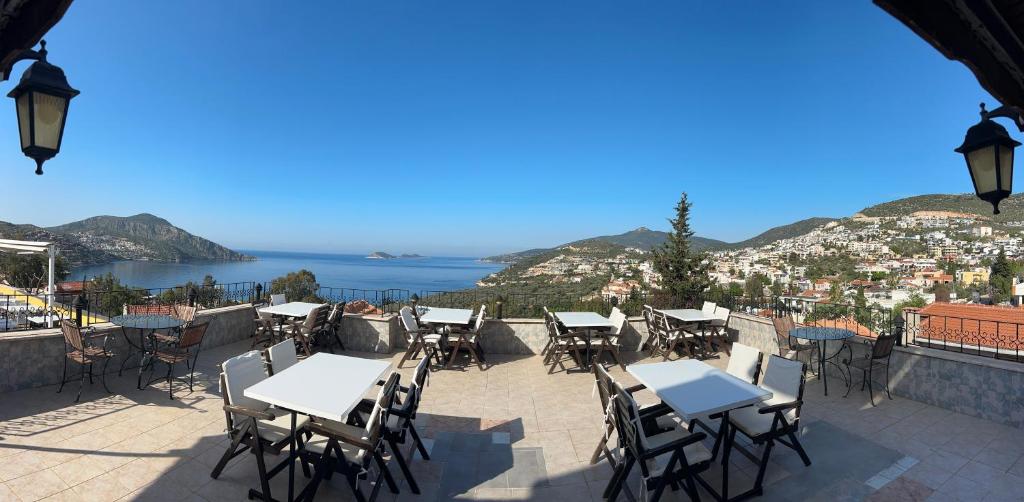 a patio with tables and chairs and a view of a city at Enda Boutique Hotel Kalkan in Kalkan