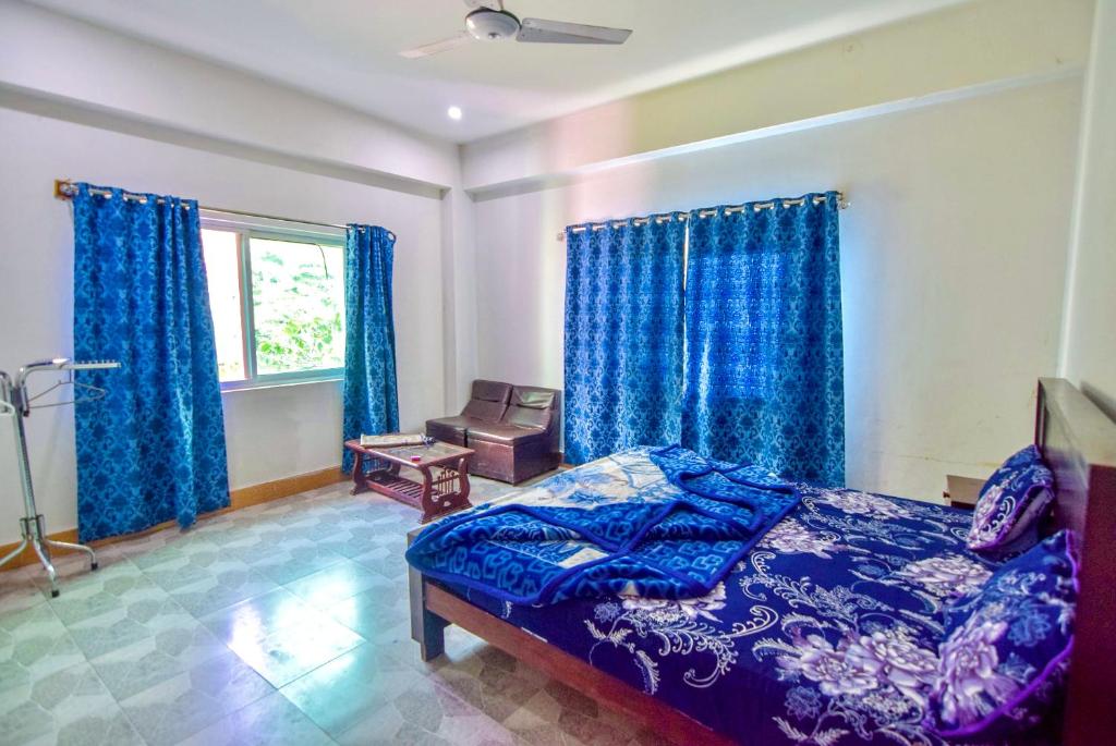 een slaapkamer met blauwe gordijnen, een bed en een raam bij Dealp hotel and restaurant kawai in Kawāi
