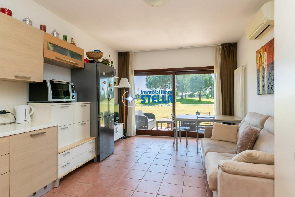 una cucina e un soggiorno con divano e tavolo di Foresteria Golf a Jesolo